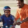 Photo: Man teaching son to ride bicycle