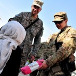 U.S. Navy Lt. Khalid Kader and U.S. Army Capt. Pamela Rusinko hand blankets to orphans at Aschiana Center (an orphanage and school), in Kabul, Nov. 30. Coalition forces handed out 14 boxes of blankets to several groups of kids, ranging in ages from five to early teens. (U.S. Navy photo by Mass Communication Specialist 3rd Class Eric Lockwood)