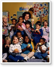 [U.S. Surgeon General Antonia C. Novello in group photo with children at a daycare center]. [1990?].