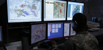 Intelligence soldier looking at multiple computer screens