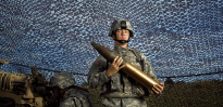 Army soldier holding an artillery shell