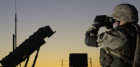Soldier views a Patriot missile through binoculars 