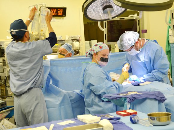 Lt. Col. Eric Lewis (left to right), chief of anesthesia and perioperative services, nurse anesthesiologist Dan Barton, operating room technician Spc. Mikayla Cornfield and general surgeon Dr. Todd Lucas work as a team during same-day surgery at U.S. Army Health Center Vicenza Oct. 2, 2012.