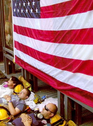 Firefighters resting under the American flag