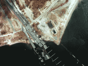 Arial photograph of a collapsed road over water.