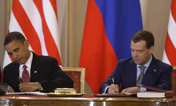 U.S. President Barack Obama, left, and his Russian counterpart Dmitry Medvedev, right, sign the newly completed New START treaty reducing long-range nuclear weapons at the Prague Castle in Prague, Czech Republic, Thursday, April 8, 2010.