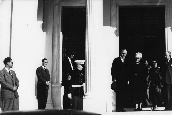 1948:  Regional Security Officer Ralph True (standing watch, second from left) and a Marine Security Guard look on as U.S. Secretary of State George C. Marshall prepares to depart Athens, Greece. (U.S. Department of State)