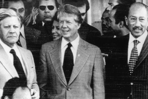 January 4, 1978:  An SY Regional Security Officer (rear, dark glasses) appears with (left to right) German Chancellor Helmut Schmidt, U.S. President Jimmy Carter, and Egyptian President Anwar Sadat during a visit to Aswan, Egypt. (Source: Associated Press)