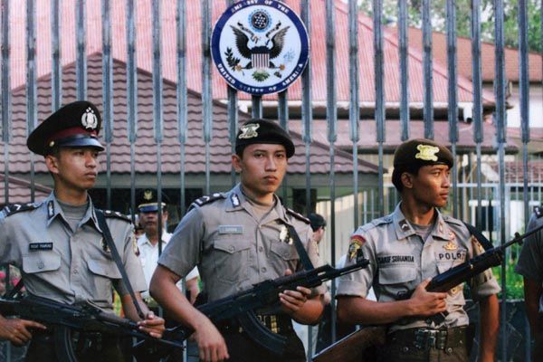 August 24, 2001:  Indonesian local guard officers armed with assault rifles stand at the U.S. Embassy compound in Jakarta as a protest is staged against American interests in the Southeast Asian country.  (Source: Associated Press)