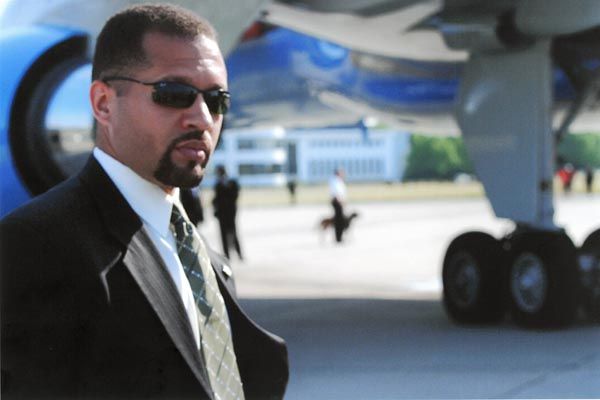 June 23, 2005:  A DS special agent stands watch on a typical airport tarmac, protecting an arriving or departing dignitary. (Source: U.S. Department of State)