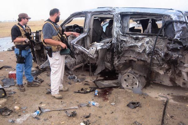 June 28, 2007:  Assistant Regional Security Officers view the wreckage of a vehicle after an insurgent attack in Kabul that left two contractors dead and three other individuals in the vehicle critically injured.  RSO and FBI Legatt personnel respond to the attack, to investigate and collect evidence. (Source: Private Collection)