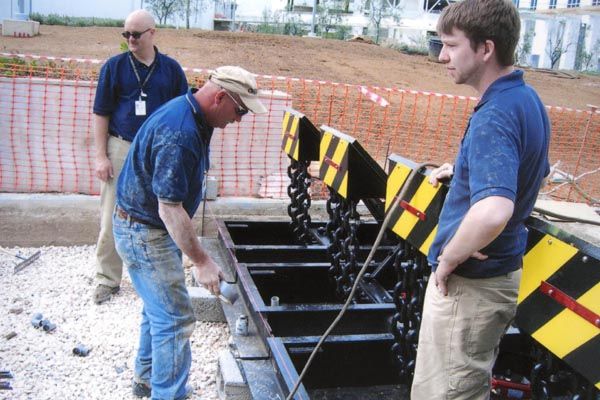 2008:  The Delta Barrier Replacement Program underway in Athens, Greece, utilizing the services of (left to right) a U.S. Navy Seabee building chief, a DS contractor, and a DS senior engineer from the Field Maintenance Section of DS Security Technology's Facility Security Engineering Division.  (Source: DS Records)