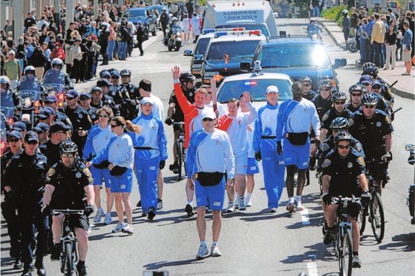 April 8, 2008:   DS special agents form the innermost layer of protection surrounding the Olympic torch during the San Francisco leg of its around-the-world journey to the torch-lighting ceremony in Beijing. (Source: Associated Press)