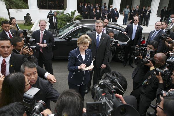 February 19, 2009:  As several Diplomatic Security special agents (rear) scan the crowd, U.S. Secretary of State Hillary Rodham Clinton signs a book for a journalist after meeting with Indonesia's President Susilo Bambang Yudhoyono at the palace in Jakarta, Indonesia.  (Source: Associated Press)