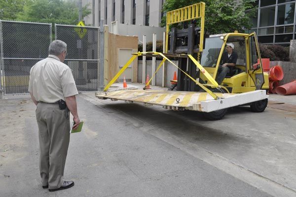 May 2009:  A DS Security Technical Specialist (left) and a DS contractor remove a vehicle barrier plate for experimental surface treatment at the Main State Department garage in Washington, DC. (Source:  Private Collection)