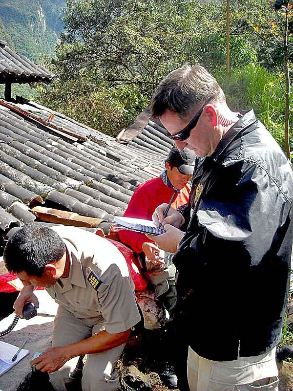 A U.S. Diplomatic Security special agent (right) coordinates with a Peruvian Air Force officer on inbound U.S. and Peruvian aircraft during the Peru-led air evacuation January 29, 2010 of residents and tourists, including U.S. citizens, from the ancient Incan citadel of Machu Picchu after heavy rains, mudslides, and severe flooding hit the region. (U.S. Department of State Photo)