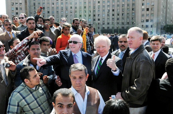 U.S. Senators John McCain (pointing, center left) and Joseph Lieberman (center right) talk to Egyptians, February 27, 2011 in Tahrir Square, site of the 2011 uprising in Cairo, Egypt. DS special agents (standing beside Senator Lieberman, at right; extreme left rear with sunglasses; and extreme right rear, partially hidden) provide security for the two senators. (Agence France-Presse photo)