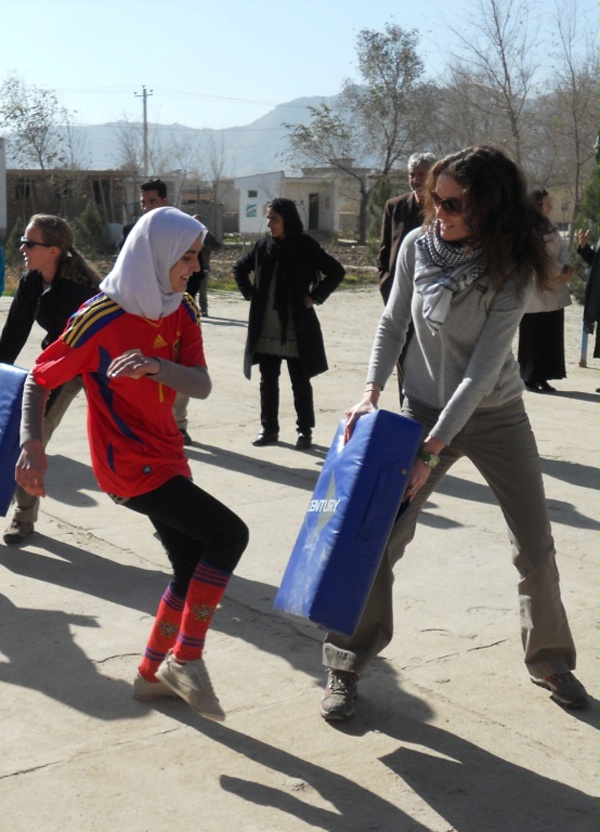 A DS assistant regional security officer (right) braces for a kick from one of the Afghanistan students who visited U. S. Embassy Kabul December 4, 2011, to learn self-defense techniques. Another DS special agent (left rear) works with other students during their exercises. (U.S. Department of State photo)