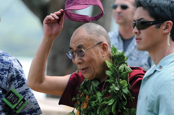 DS special agents (right and rear) provide security for His Holiness the Dalai Lama, spiritual leader of Tibet, seen lifting his cap in greeting to well-wishers as he arrives April 4, 2012, for an interview in Honolulu, Hawaii. (Honolulu Star-Advertiser)