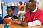 On April 3, 2008, Foster Grandparent Enoch Nelson works with a student on reading comprehension at St. Paul Primary School in Summerton, South Carolina.