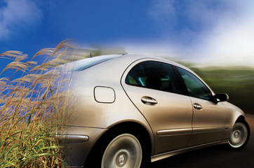 Photo of switchgrass feedstock and car in motion