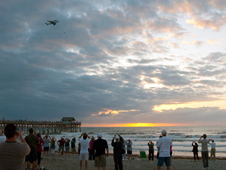 Observers near the Cocoa Beach Pier watch as Discovery flies over area beaches