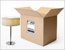 Image of an open shipping box and a lamp.
