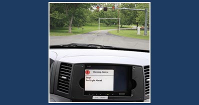  An advisory message, “Stop! Red Light Ahead,” appears on a display on the dashboard in the Cooperative Vehicle-Highway test vehicle as it approaches the intelligent intersection at Turner-Fairbank. The message is an example of a real-time safety alert that could be provided to motorists.