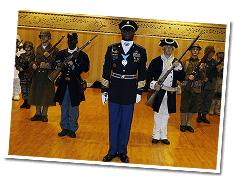 Soldiers stand in formation, dressed in different uniforms from many time periods.