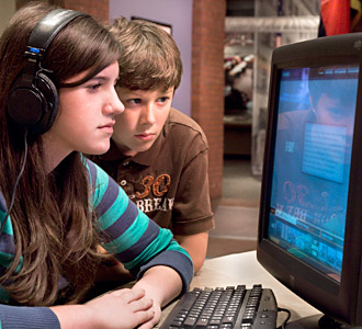 Two students visiting the U.S. Holocaust Memorial browse an interactive display in the Museum's Wexner Learning Center.