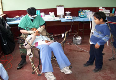 While at the Huacho clinic, LT Sheila Weagle, a dental hygienist, performs an oral exam on a pediatric patient.