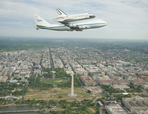 Image description: This morning the Space Shuttle Discovery took a final flight around Washington, D.C. perched on top of a 747 jet before being transferred to its final resting place in the National Air and Space Museum&#8217;s Udvar-Hazy Center in Virginia.
The remaining space shuttles will be transferred to various museums and visitors centers throughout the country.
Space Shuttle Enterprise is scheduled to head to New York on April 23.
Space Shuttle Atlantis will be moved to the Kennedy Space Center in Florida, with the new visitor center to open as early as summer 2013.
Space Shuttle Endeavour will rest in the California Science Center in Los Angeles, tentatively slated to happen in later 2012.
Learn more about NASA&#8217;s special 747 jet that transfers the shuttles after their missions are complete.
If you were in DC today and saw the shuttle fly by, you can share your photos from the event.
Photo by NASA.