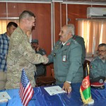 US Army Col. Keith Detwiler, Regional Support Command-West commander and Afghan National Police Col. Fazi Ahmad Khalili, Adraskan National Training Center commander, shake hands after transitioning the training center to Afghan control in a ceremony held at the site Sept. 29. (US Navy photo by LT. David P. Varney, RSC-W/NTM-A PAO)