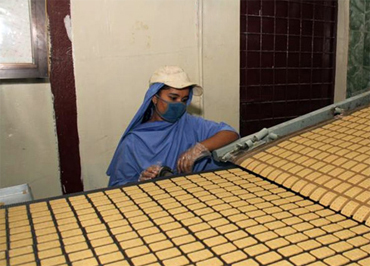 A Bangladeshi factory worker monitors the production of biscuits made from U.S. donated wheat. The donation was delivered to the World Food Programme, a Foreign Agricultural Service (FAS) McGovern-Dole program participant that works to provide food assistance in more than 73 countries. The biscuits will be distributed to about 2,000 schools in the poorest areas of Bangladesh. (Photo courtesy U.S. Embassy New Dehli)