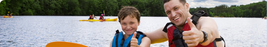 Close up photo of an adult and child who are kayaking