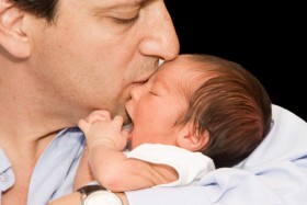 Dad kissing newborn