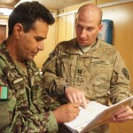 Lt. Col. Ibrahim Wardak and Capt. Kevin Sirucek review transportation records in the Joint Logistics Cell of NATO Training Mission-Afghanistan.  Improvements to the transportation process have created daily savings in excess of $21,000.