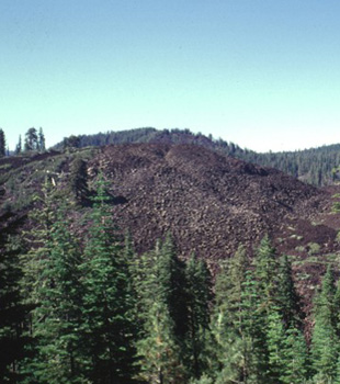 Devil\'s Garden, the blocky lava flow in the foreground, forms part of Tumble Buttes.