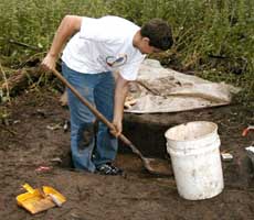 (photo) Archeologist uses a shovel to excavate. (Midwest Archeological Center)