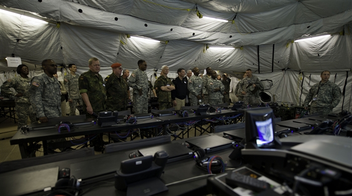 GRAFENWOEHR, Germany - A group of distinguished visitors listen to a brief about the capabilities of the deployable joint command and control tent during Combined Endeavor (CE) 2012 Distinguished Visitors Day, Joint Multinational Training Command, Grafenwoehr, Germany, Sept. 13, 2012. CE12 is a multinational command, control, communications and computer systems exercise designed to build and enhance communications and network interoperability between 41 nations and international organizations.