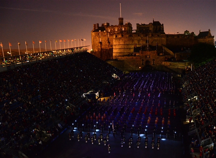 Multinational musicians and performers stand in formation as the "Lone Bagpiper" plays a memorial tribute for U.K. troops who have died serving the nation at home and abroad. This year's memorial also commemorated the war to liberate the Falkland islands. This military tattoo brings together musicians, dancers and bagpipers from around the world to perform in Europe’s most prestigious military tattoo and this year marks the first time since 1950 that a Navy band has performed in the show.