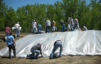 Volunteers construct an 8 to 10 ft. berm around the Mni Wiconi Intake Structure to provide protection against flood waters.