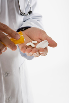 Image of a doctor pouring out a bottle of pills.