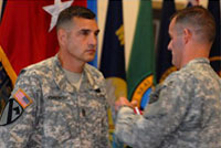 Combined Arms Center Command Sgt. Maj. Philip Johndrow stands before a full room of friends, service members and post employees as acting CAC and Fort Leavenworth Commander Brig. Gen. Charles Flynn pins him with the Distinguished Service Medal Oct. 3 at the Frontier Conference Center.