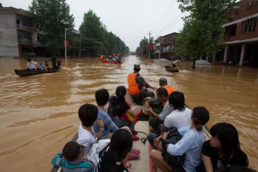 Officials assist with evacuations of affected areas in the wake of 2010 floods across central and southern China. 