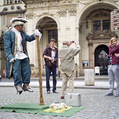 Above, a street artist performs for tourists on the streets of Prague.