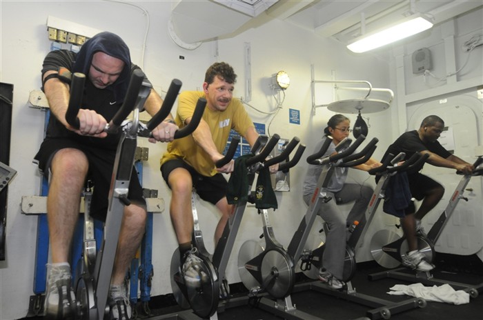 USS KEARSARGE, At Sea  (Mar. 11, 2011) -- Ensign Adam Galazka, Lt. Jim McLean, Lt. Carol Pena, and Lt. Dwight Jefferson log miles on the exercise bikes in the gym during the"Crews Into Shape" competition aboard USS Kearsarge (LHD 3). The competition is a nutritional and physical fitness competition to assist Sailors in leading a healthier lifestyle.  Kearsarge is the command ship of Kearsarge Amphibious Ready Group supporting maritime security operations and theater security cooperation efforts in the U.S. 6th Fleet area of responsibility. (U.S. Navy Photo By Mass Communication Specialist 2nd Class (SW) Stevie Tate/Released)