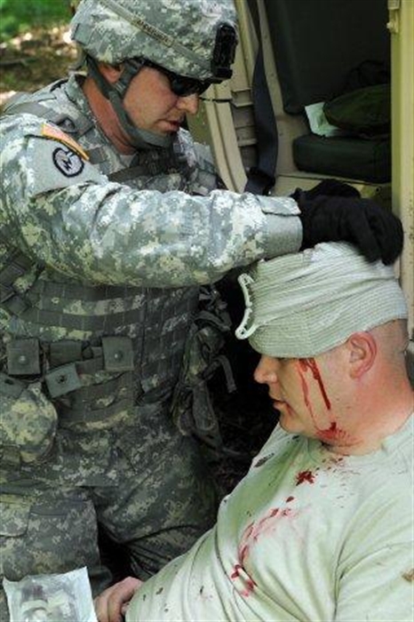 SPC David Anderson, assigned to Joint Tactical Ground Station (JTAGS) in Stuttgart Germany, provides First Aid to SPC Preston Hardin who was suffered injury to the head during the First Aid portion of the Warrior Field Exercise WFTX). First Aid is one of the requirements for the Army’s annual Warrior Training Exercise.