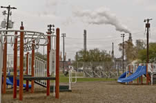 Playground with smokestacks nearby in the background