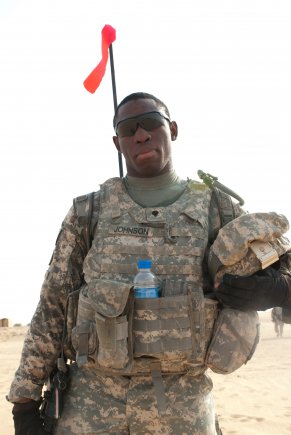 Spc. Josiah Johnson, of A Company, 4th Battalion, 118th Infantry Regiment, poses after he and other battalion Soldiers completed a platoon live-fire exercise at the Udairi Range Complex in northern Kuwait, July 31, 2012. The Soldiers assaulted and cleared buildings and a trench system during the exercise. Attached to Johnson's equipment is the highly-visible, flag-like device known as a progress pole. As the name implies, a progress pole shows the assault element's progress and location as they clear a trench, so troops providing fire support know where to shoot safely and effectively. In addition to undertaking camp and security-force operations, the South Carolina Army National Guard Soldiers have kept up the pace of their training since deploying to Kuwait in April. Johnson is from Cross, S.C.